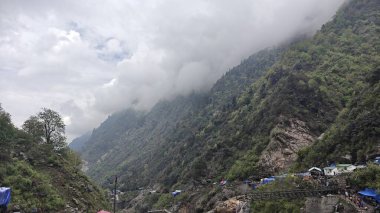 Dükkanları olan sisli dağların güzel manzarası, Kedarnath Tapınağı Yolu 'ndaki Shiva fanatikleri için oteller.