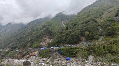 Dükkanları olan sisli dağların güzel manzarası, Kedarnath Tapınağı Yolu 'ndaki Shiva fanatikleri için oteller.