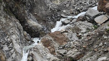 Dağlardaki kayalardan akan küçük akarsuyun manzarası.