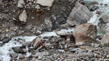 Dağlardaki kayalardan akan küçük akarsuyun manzarası.
