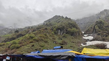 Dağların manzarası ve bulutlu gökyüzüne karşı çadırları 