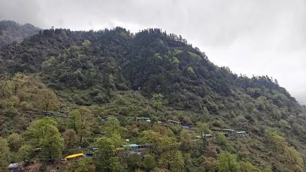 Dükkanları olan sisli dağların güzel manzarası, Kedarnath Tapınağı Yolu 'ndaki Shiva fanatikleri için oteller.