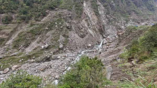 Yeşil dağlardaki kayalardan akan küçük akarsuyun manzarası.