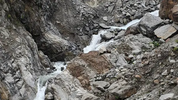 Dağlardaki kayalardan akan küçük akarsuyun manzarası.