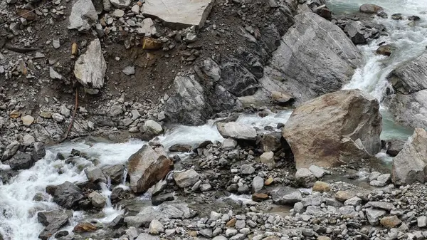 Dağlardaki kayalardan akan küçük akarsuyun manzarası.