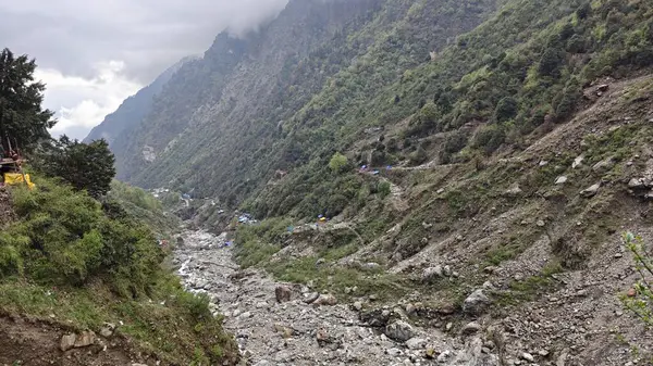 Yeşil dağlardaki kayalardan akan küçük akarsuyun manzarası.