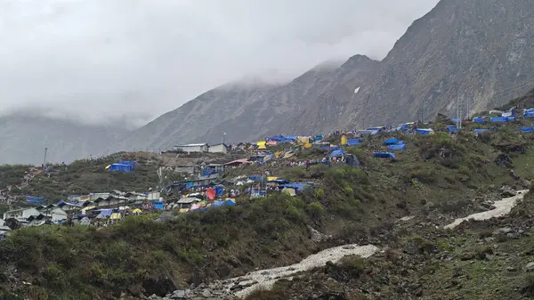 Dükkanları olan sisli dağların güzel manzarası, Kedarnath Tapınağı Yolu 'ndaki Shiva fanatikleri için oteller.