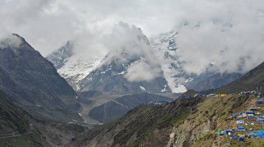 Sis ve dağ köyüyle kaplı güzel karlı dağların manzarası.