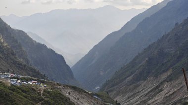 Yeşil çayırların güzel manzarası, mavi gökyüzü karlı dağlar, mağazalar, oteller ve Kedarnath Tapınağı Yolu 'na giden Shiva hayranlarından oluşan kalabalık.