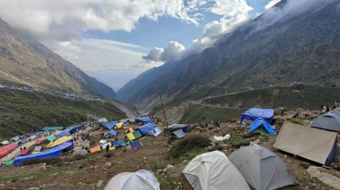 Yeşil çayırların güzel manzarası, mavi gökyüzü karlı dağlar, mağazalar, oteller ve Kedarnath Tapınağı Yolu 'na giden Shiva hayranlarından oluşan kalabalık.