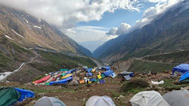 Yeşil çayırların güzel manzarası, mavi gökyüzü karlı dağlar, mağazalar, oteller ve Kedarnath Tapınağı Yolu 'na giden Shiva hayranlarından oluşan kalabalık.