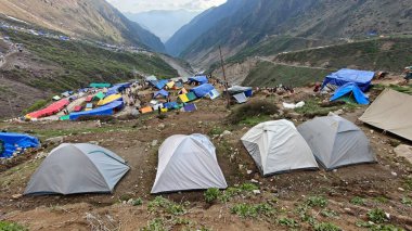Yeşil çayırların güzel manzarası, mavi gökyüzü karlı dağlar, mağazalar, oteller ve Kedarnath Tapınağı Yolu 'na giden Shiva hayranlarından oluşan kalabalık.
