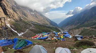Yeşil çayırların güzel manzarası, mavi gökyüzü karlı dağlar, mağazalar, oteller ve Kedarnath Tapınağı Yolu 'na giden Shiva hayranlarından oluşan kalabalık.