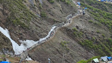 Yeşil çayırların güzel manzarası, mavi gökyüzü karlı dağlar, mağazalar, oteller ve Kedarnath Tapınağı Yolu 'na giden Shiva hayranlarından oluşan kalabalık.