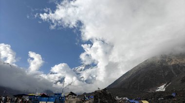 Yeşil çayırların güzel manzarası, mavi gökyüzü karlı dağlar, mağazalar, oteller ve Kedarnath Tapınağı Yolu 'na giden Shiva hayranlarından oluşan kalabalık.
