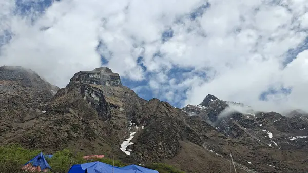 Himalaya dağlarında çadırlar ve bulutlu mavi gökyüzü 