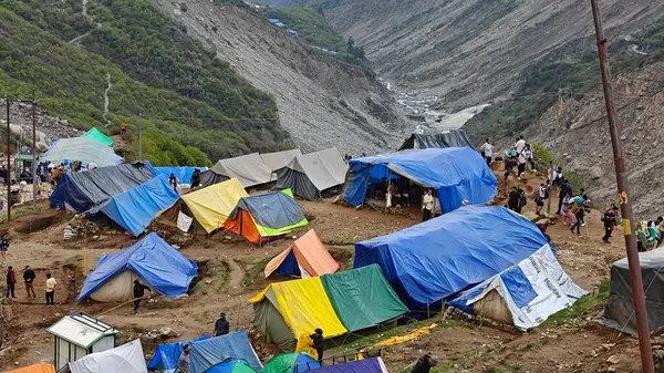 Yeşil çayırların güzel manzarası, mavi gökyüzü karlı dağlar, mağazalar, oteller ve Kedarnath Tapınağı Yolu 'na giden Shiva hayranlarından oluşan kalabalık.