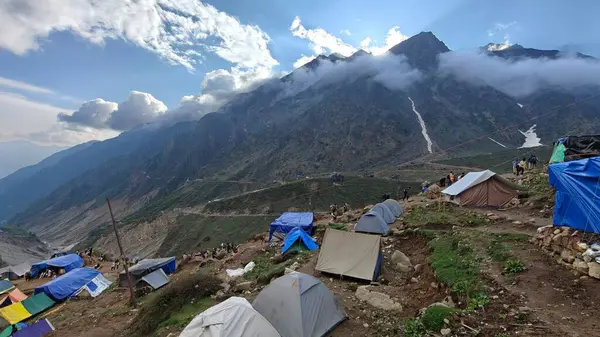 Yeşil çayırların güzel manzarası, mavi gökyüzü karlı dağlar, mağazalar, oteller ve Kedarnath Tapınağı Yolu 'na giden Shiva hayranlarından oluşan kalabalık.