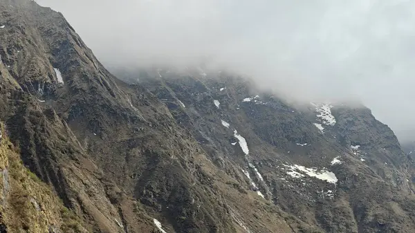 Yeşil çayırların güzel manzarası, mavi gökyüzü karlı dağlar, mağazalar, oteller ve Kedarnath Tapınağı Yolu 'na giden Shiva hayranlarından oluşan kalabalık.