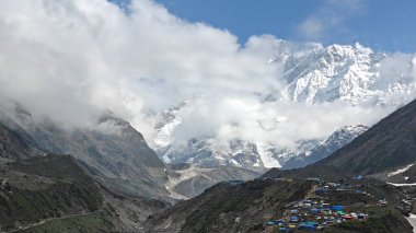 Karlı Himalaya dağları ve mavi gökyüzünde bulutlarla güzel bir manzara.
