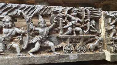 Güney Hindistan tapınağı savaş sahnesiyle rahatladı. 12. yüzyıldan kalma Hindu yapısı duvarında savaşan ok ve yaylı savaşçılar, Halebidu, Hindistan.