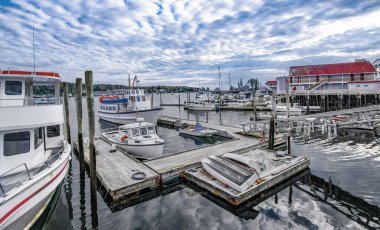 Küçük New England Liman Kasabası: Boothbay Harbor, Maine 'de akşam saatlerinde bulutlu bir Ekim ayında balıkçılık, yelkencilik ve turne tekneleri toplanıyor.