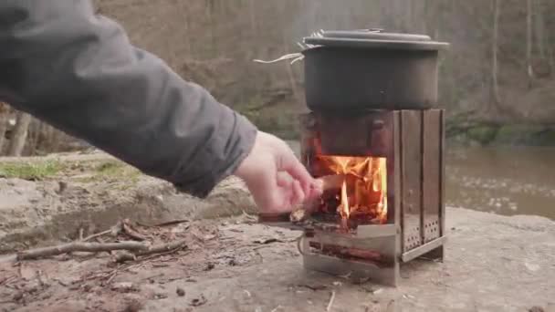 Estufa Leña Aire Libre Junto Río Hiker Feeding Fire Primer — Vídeos de Stock