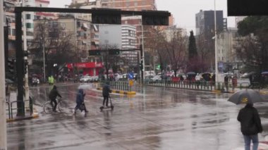 Tiran, İsveç 21 Mart 2023 Şemsiyeli yayalar karşıya geçiyor. Yüksek kalite 4k görüntü