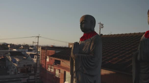 Japansk Buddha Skulptur Med Röda Haklappar Vid Solnedgången Andlig Scen — Stockvideo