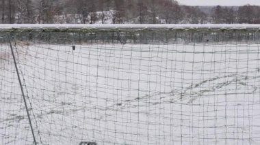 Futbol sahasında Kar İzleri Futbol Ağı 'ndan görülüyor, Pan şutu. Yüksek kalite 4k görüntü
