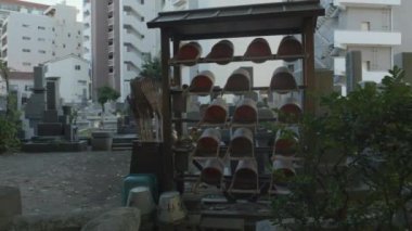 Fukuoka 'daki Geleneksel Japon Mezarlığı' nda kovaları taştan fenerlerle sulamak. Yüksek kalite 4k görüntü