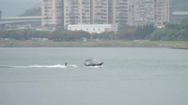 Taiwan, Tamsui Nehri 'ndeki teknenin arkasında su kayağı. Yüksek kalite 4k görüntü