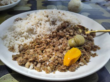 Geleneksel Gambiya Nyebbeh menüsünde pilav, siyah göz bezelyesi ve beyaz tabakta Scotch Bonnet Pepper.