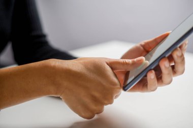 Telefonun kilidini açmak için parmak izi taraması yapan cep telefonu sahibi. Kişisel verilerin sıkı bir şekilde korunmasını gerektiren kişisel cihaz güvenliği kavramı.