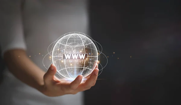 Female hand holding a virtual globe with a website icon with the letters WWW and continuous lines around the globe.