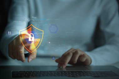 Dijital varlıklar için koruma. Teknolojiden anlayan iş adamı bilgisayarında dijital kalkan, güvenli ağ ve aşılmaz savunma olan verileri koruyor. Siber güvenlik kavramı. 