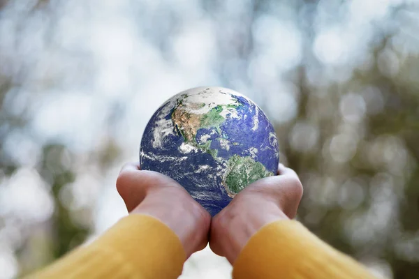 ESG , Environmental, Social and Governance concept. A globe in human hands showing support and protection. Elements of this image furnished by NASA.