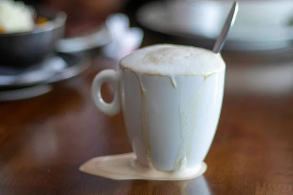 一杯咖啡洒在周围 咖啡上有很多泡沫 — 图库照片