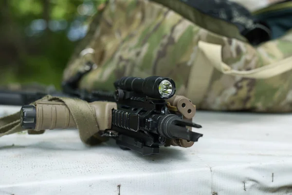 airsoft weapon hk416, black weapon on the table with a flashlight