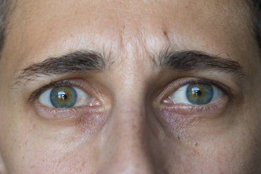 Uzun kıvırcık saçlı, güneş gözlüklü bir kadının portresi.