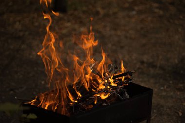 Karanlıkta alevler, karanlık arka planda parlak bir ateş.