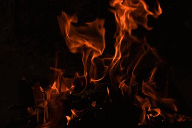 Karanlıkta alevler, karanlık arka planda parlak bir ateş.