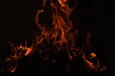 Karanlıkta alevler, karanlık arka planda parlak bir ateş.