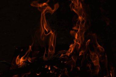 Karanlıkta alevler, karanlık arka planda parlak bir ateş.