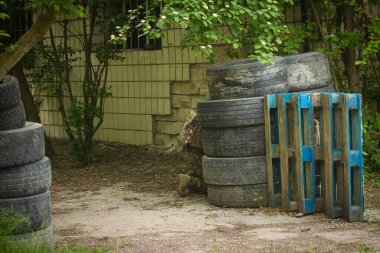 Sokak ortasında terk edilmiş binaların yanında, Amerikan üniformalı bir adam bir sığınağın arkasına saklanıyor.