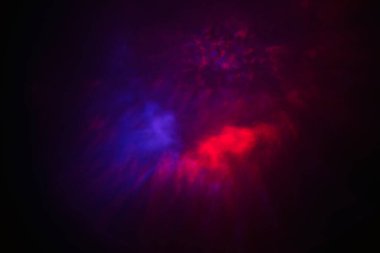 Kozmik renklerin büyüleyici bir görüntüsü, pembe, yeşil ve kırmızı renklerin parlak yıldızımsı noktalarla çevrili, uzaydaki bir nebulayı andıran canlı bir patlaması..