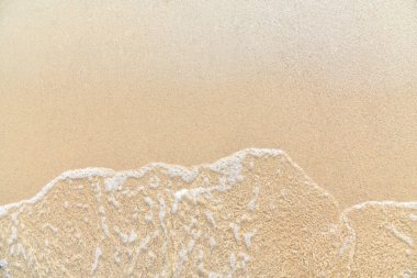 Kumsal ve dalgalar yukarıdan görünüyor. Kum ve deniz arka planı yukarıdan görünüyor. Havadan gelen yaz deniz manzarası. İHA 'nın üst görüntüsü. Seyahat konsepti ve fikri