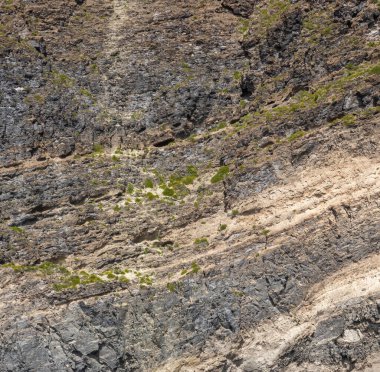 Yıpranmış deniz kenarındaki kaya yüzeyi dokusu. Yaşlanmış volkanik duvar yüzeyinin arka planında çatlaklar ve çizikler var. Ischia Adası, İtalya.