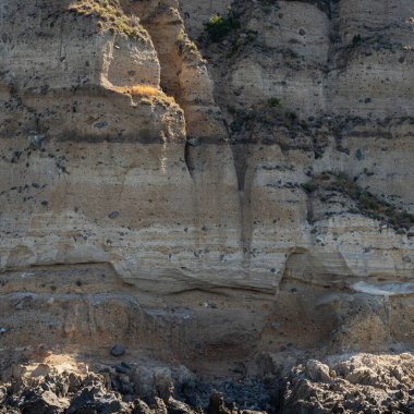 Yıpranmış deniz kenarındaki kaya yüzeyi dokusu. Yaşlanmış volkanik duvar yüzeyinin arka planında çatlaklar ve çizikler var. Ischia Adası, İtalya.