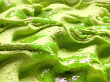 Dondurulmuş Kivi aromalı dondurma, tüm çerçeve detaylarıyla. Üzeri şurupla kaplı yeşil bir dondurma yüzey dokusunu kapat..